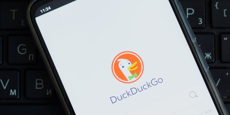 DuckDuckGo browser app open on a smartphone resting on a keyboard
